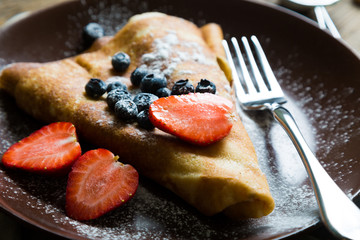 Pancakes with fresh berries and icing sugar