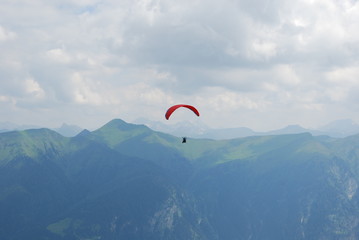 Red parachute in the alps in summer