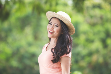 Beautiful young asian woman wearing round hat on a park