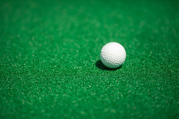 ball for golf on a green field. a white ball for golf.