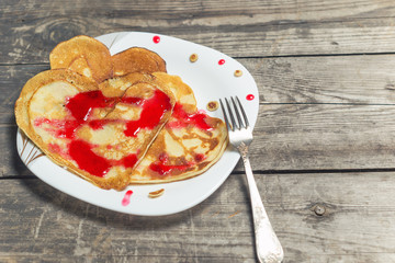Pancakes on a plate in the form of hearts with blueberry jam