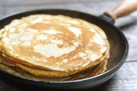 Stack of pancakes on a cast-iron frying pan. Rustic.