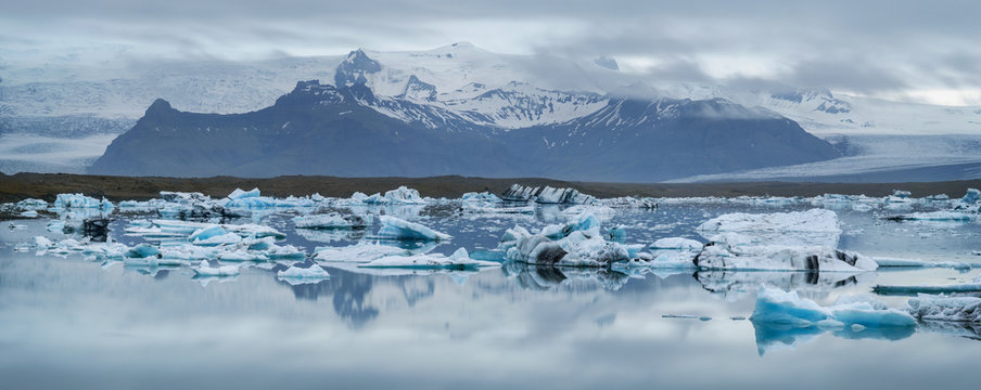 Glacier on the mountains and floating icebergs in lagoon in Iceland