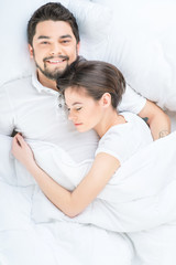 Obraz na płótnie Canvas Nice loving couple lying in bed 