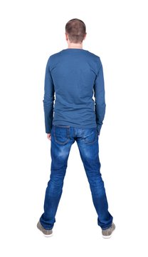 Back view of young man in t-shirt and jeans  looking