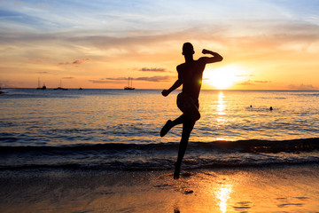 Plakat African men jumping at Sunset in Tarrafal beach in Santiago is