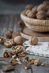 Walnut kernels and whole walnuts on rustic old wooden table