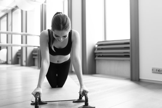 Woman doing push ups exercise. Powerful female exercising in health club.