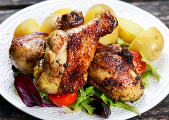 Baked chicken legs with potatoes and vegetables
