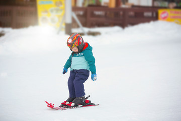 Fototapeta na wymiar toddler boy skiing in the mountains, winter time