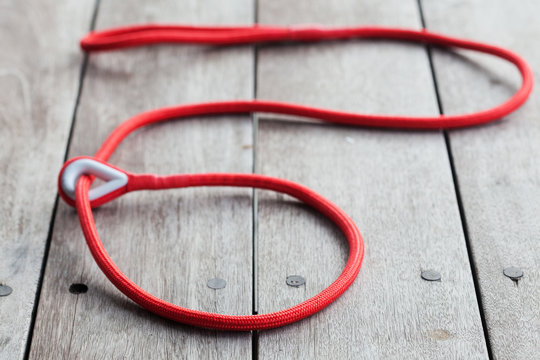 Red Dog Leash On A Wooden Table.