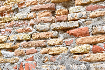 Brick wall is worn and textured by weather