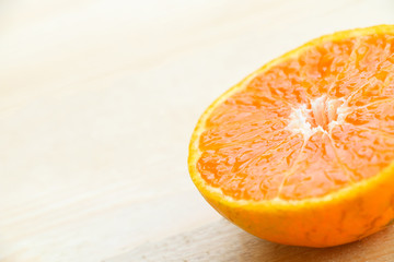 Organic orange fruit. Slices on soft wooden background