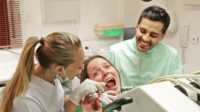 Dentist, assistant and scared patient at surgery office