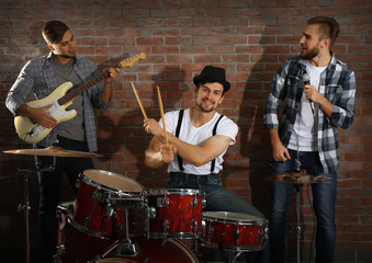 Fototapeta na wymiar Musicians playing the drums on brick wall background