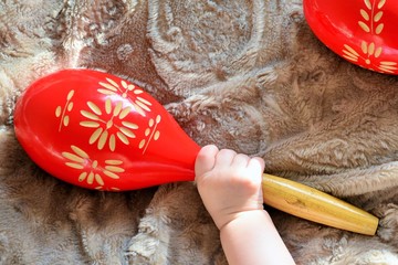 Baby hand catching one of two maracas