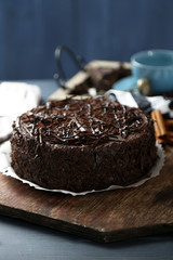 Tasty chocolate cake on color wooden background