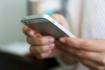 Woman holding smartphone indoors