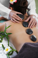 Obraz na płótnie Canvas Woman getting a hot stone massage at spa salon