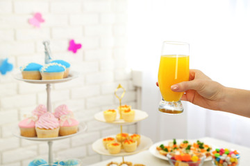 Woman holding glass of juice on buffet background