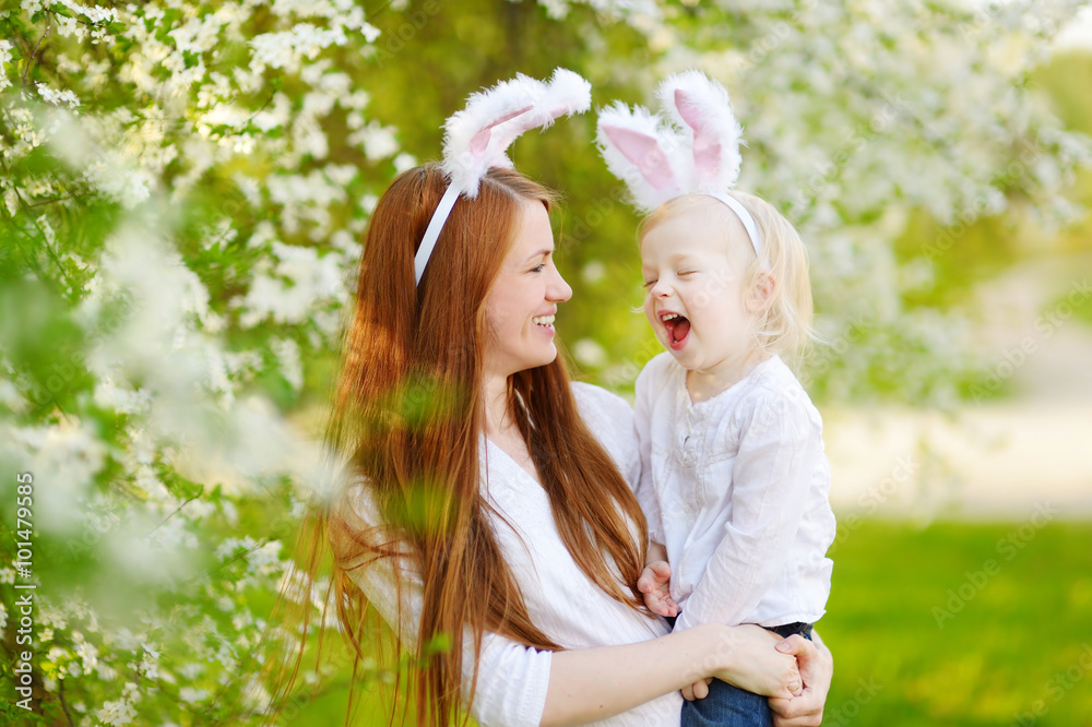 Wall mural young mother and her daughter wearing bunny ears on easter day