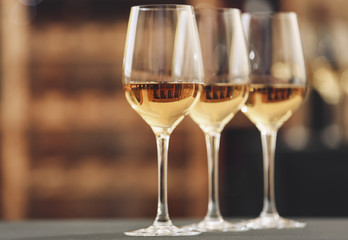 Glasses with white wine on blurred background