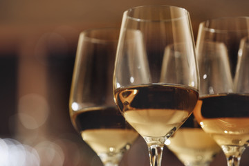 Glasses with white wine on blurred background