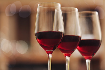 Glasses with red wine on blurred background
