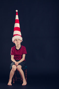 Young boy in a red and white striped dunce cap
