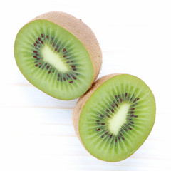 Fototapeta premium Demi kiwis sur fond bois blanc