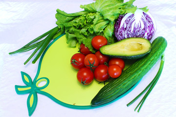 Still life of vegetables and greens on a cutting board
