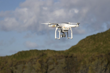 small unmanned helicopter with a camera flying in the blue sky a
