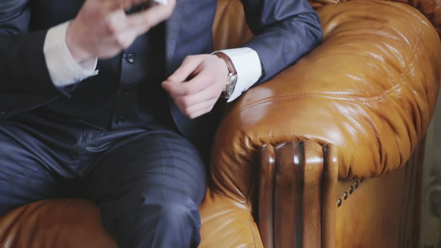 attractive young man in a suit sitting on a retro couch