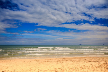 Fototapeta na wymiar View of Foamy Wave Surf on Sand Beach Blue Sky