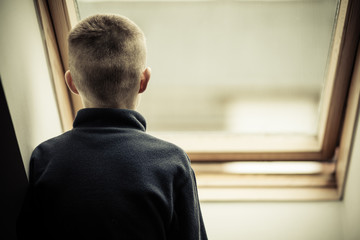 Lonely Young Boy Looking Through Glass Window