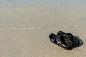 Fototapeta na wymiar Flip flops on a sandy ocean beach