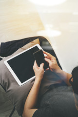 Obraz premium top view of hipster hands using smart phone and digital tablet p