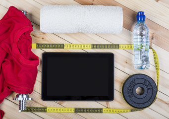 Sport Equipment. Barbell, Weight, Red Shirt, Bottle Of Water, Towel, Tape Measure And Tablet To Workout Plan On Wooden Boards. Sport Fitness Background