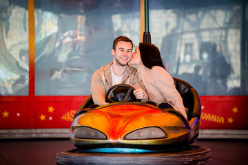 Young couple riding car in amusement park