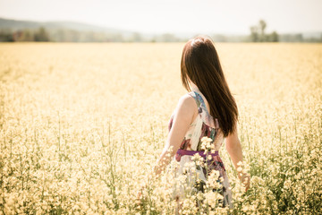 Fototapeta na wymiar Young woman in rapeseed field