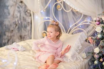 Fototapeta premium the little girl near a Christmas fir-tree