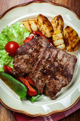 Portions of grilled beef steak with grilled potatoes and paprika