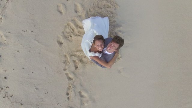 Just-married couple on a caribbean beach, wedding day - drone view