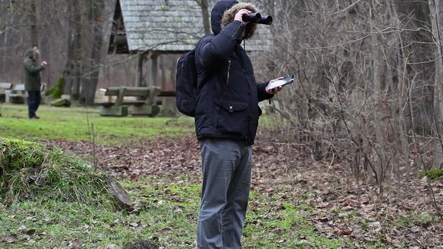 Ornithologists in the park with binoculars and camcorder
