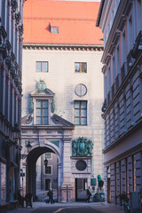 Fototapeta premium Beautiful vibrant multicolored downtown picture of street in Munich, Bayern, Bavaria, Germany, leading to Marienplatz, with tourists and people walking near shop-windows and restaurants