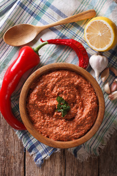 Red Muhammara and ingredients close-up. Vertical top view
