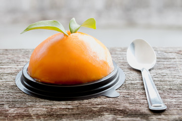 orange cake and stainless spoon on wood table
