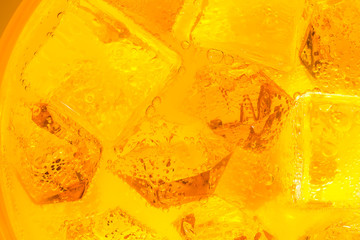 Close-up of ice cubes in orange juice