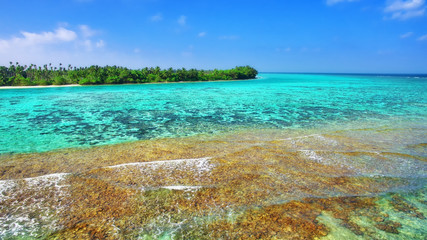 Shoreline of a tropical island in the Maldives and view of the I