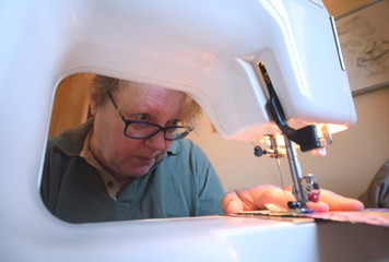 Woman working on a craft project using domestic sewing machine at home